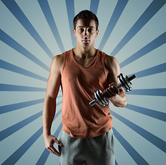 Image showing young man with dumbbell flexing biceps