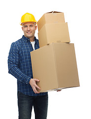 Image showing smiling man in helmet with cardboard boxes