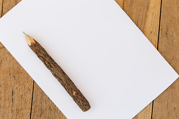 Image showing white blank paper sheet with wooden pen on table 