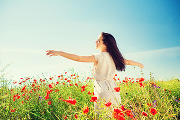 Image showing smiling young woman on poppy field