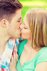 Image showing smiling couple kissing and hugging in park
