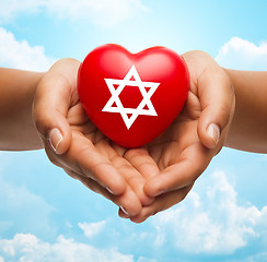 Image showing close up of hands holding heart with jewish star