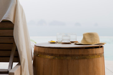 Image showing glasses of water with hat on barrel at hotel beach