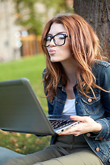 Image showing happy student girl writing to notebook at campus