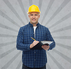 Image showing smiling male builder in helmet with clipboard