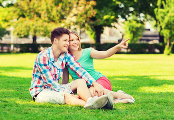 Image showing smiling couple sitting on grass in park