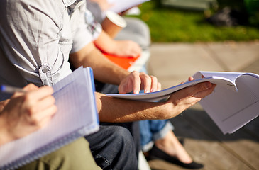 Image showing close up of students with notebooks at campus