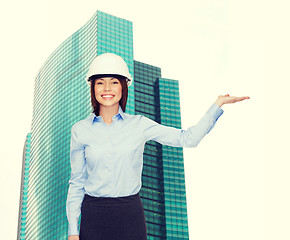 Image showing businesswoman in helmet holding something on palm