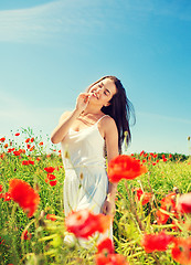 Image showing smiling young woman on poppy field