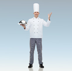 Image showing happy male chef cook holding cloche