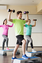 Image showing group of people with dumbbells and steppers