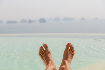 Image showing closeup of male feet over sea and sky on beach