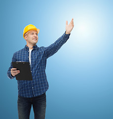 Image showing smiling male builder in helmet with clipboard