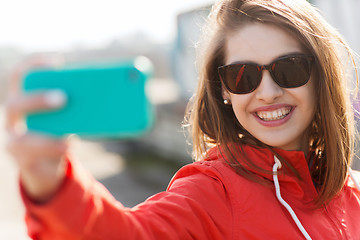 Image showing smiling young woman taking selfie with smartphone