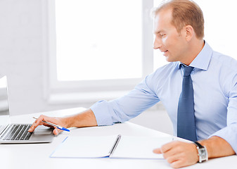 Image showing smiling businessman working in office