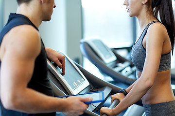 Image showing close up of woman with trainer on treadmill in gym