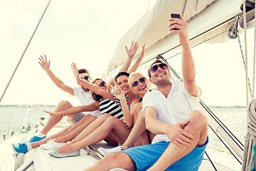 Image showing smiling friends sitting on yacht deck