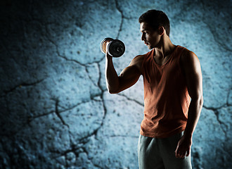 Image showing young man with dumbbell flexing biceps