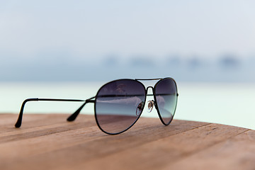 Image showing shades or sunglasses on table at beach