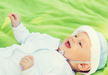 Image showing smiling baby lying on floor and looking up