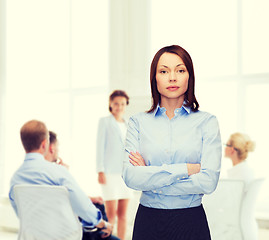 Image showing smiling businesswoman with crossed arms at office