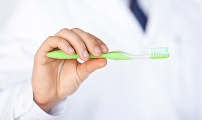 Image showing dentist or stomatologist holding toothbrush