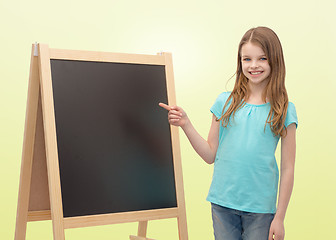 Image showing happy little girl with blackboard and chalk