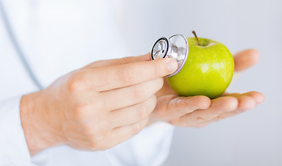 Image showing male doctor with green apple and stethoscope