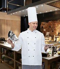 Image showing happy male chef cook opening cloche