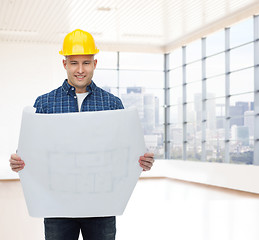 Image showing smiling male builder in helmet with blueprint