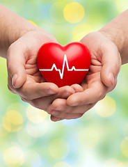 Image showing close up of hands holding heart with cardiogram