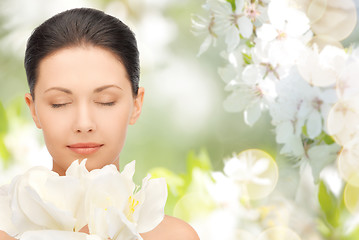 Image showing beautiful woman smelling flowers with closed eyes