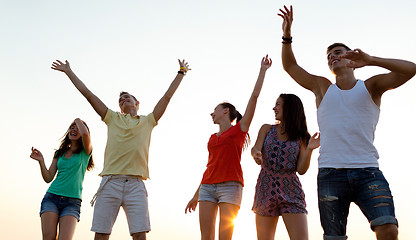 Image showing smiling friends dancing on summer beach