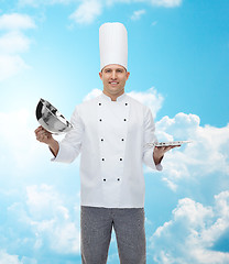 Image showing happy male chef cook opening cloche