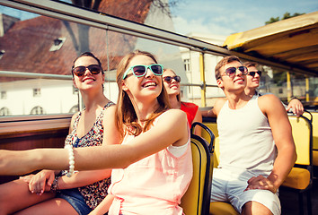 Image showing group of smiling friends traveling by tour bus