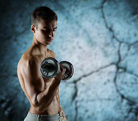 Image showing young man with dumbbell flexing biceps