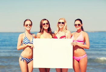 Image showing group of smiling women with blank board on beach