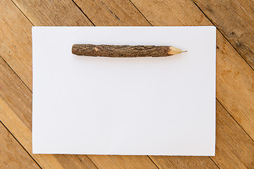 Image showing white blank paper sheet with wooden pen on table 