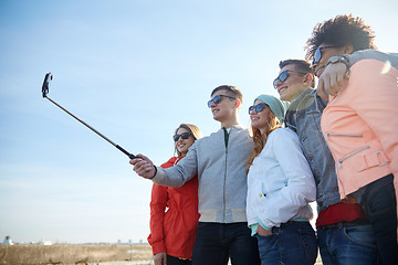 Image showing smiling friends taking selfie with smartphone