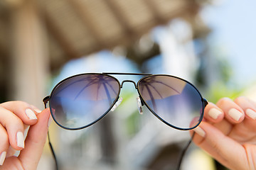 Image showing close up of hands holding shades or sunglasses