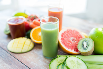 Image showing close up of fresh juice glass and fruits on table