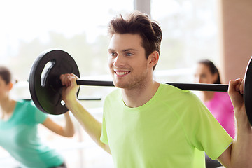 Image showing group of people exercising with barbell in gym