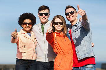 Image showing happy teenage friends in shades hugging outdoors