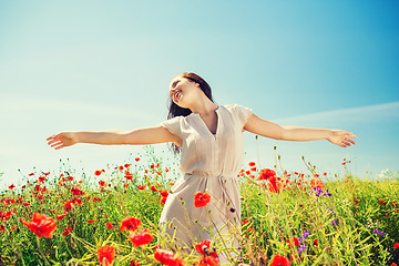 Image showing smiling young woman on poppy field