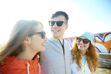 Image showing happy teenage friends in shades talking on street