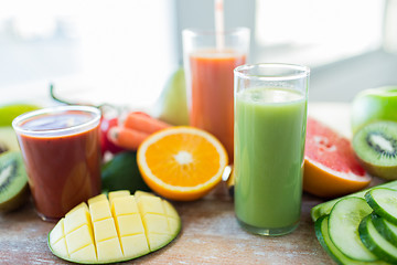 Image showing close up of fresh juice glass and fruits on table