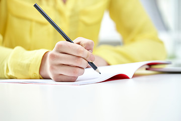 Image showing close up of female hands writing to notebook