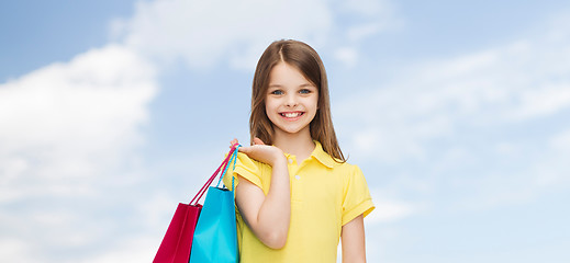 Image showing smiling little girl in dress with shopping bags