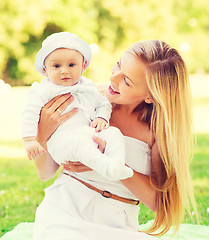 Image showing happy mother with little baby sitting on blanket