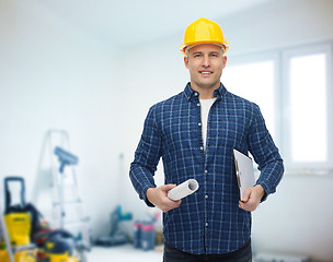 Image showing smiling male builder in helmet with blueprint